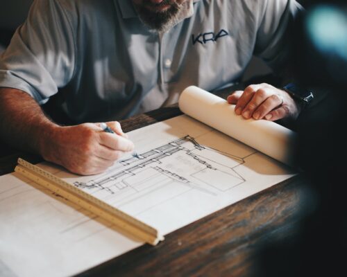 An architect working on a draft with a pencil and ruler